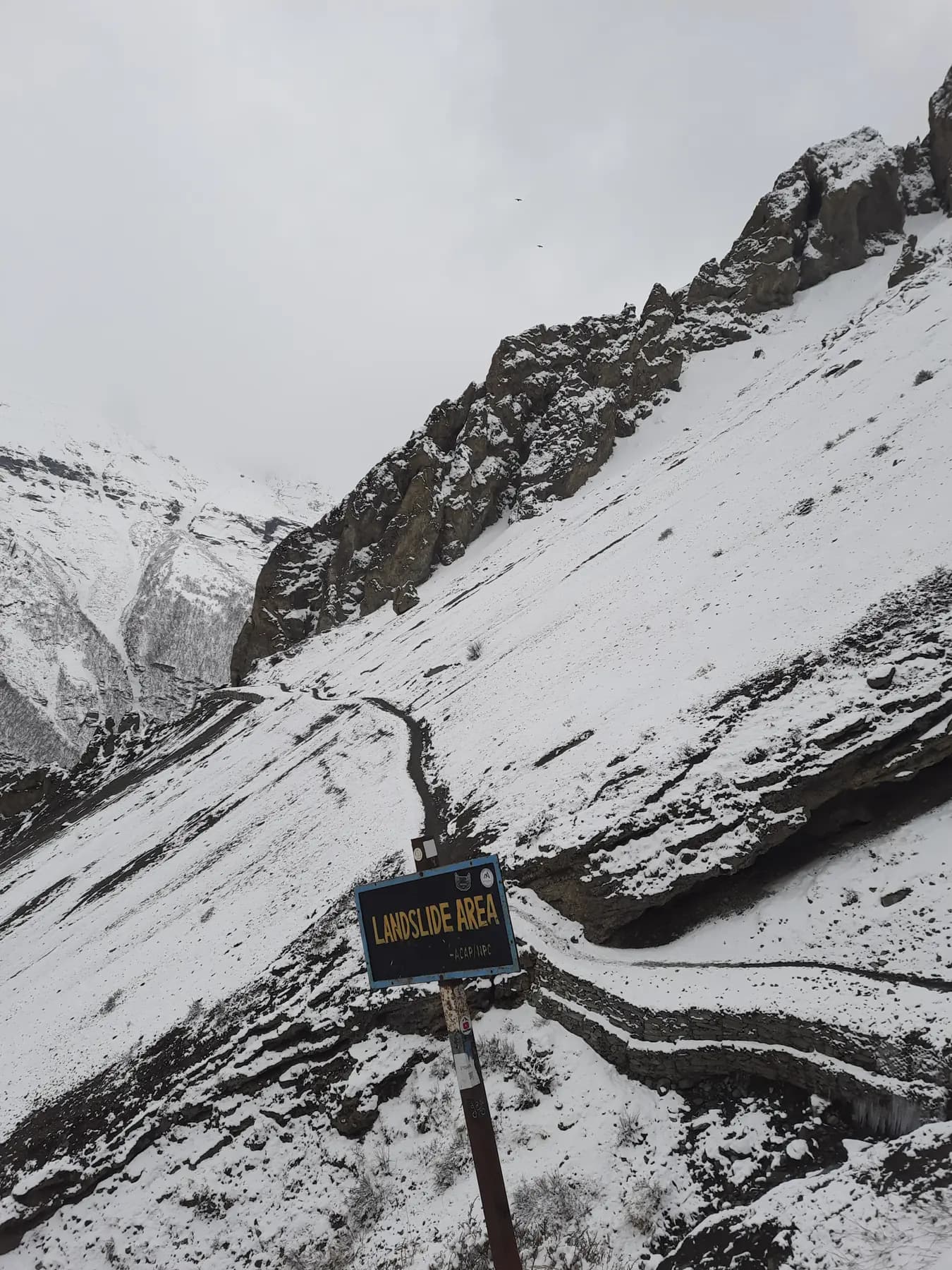 Switchback trail in snow climbing towards a high pass