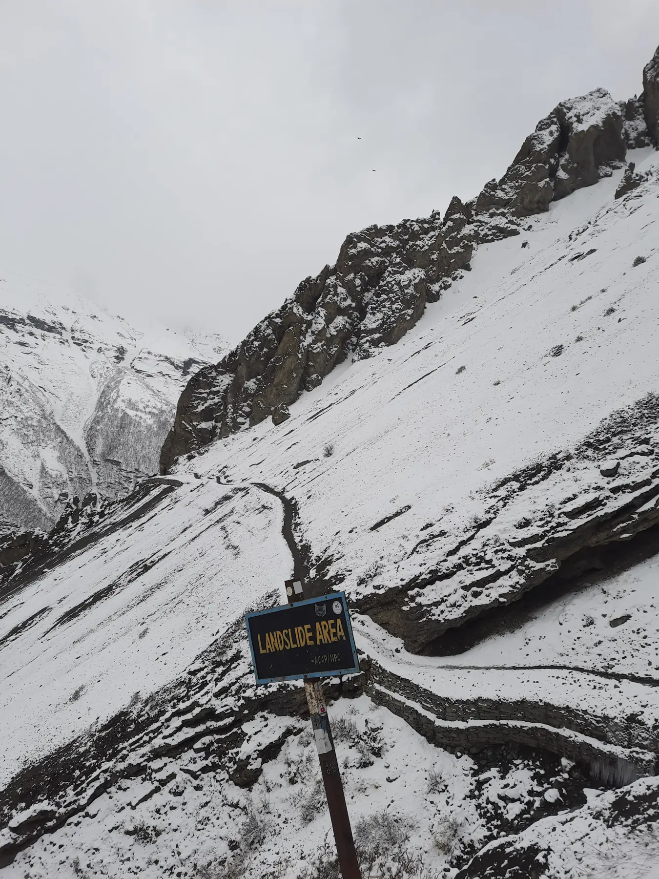 Switchback trail in snow climbing towards a high pass