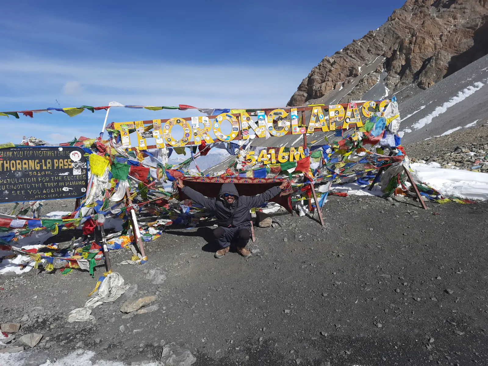 Prayer flags at the Thorong La pass sign, 5,416 m, Annapurna Circuit